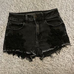 Women size 0 cut-off black denim shorts with lace decoration.